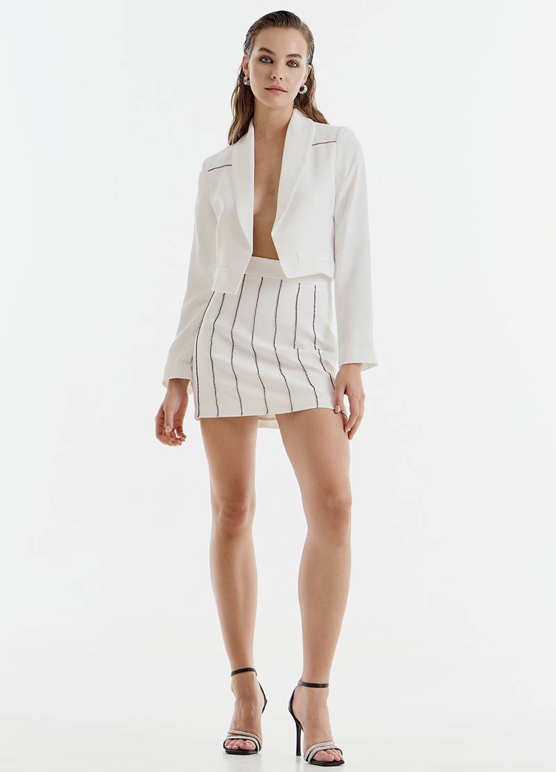 Cropped blazer with an open back and distinctive rhinestone details in white in London, UK